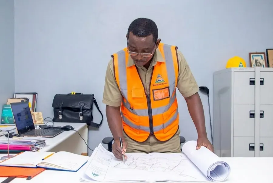 Walter Okoth, principal licensed surveyor, reviewing survey plans